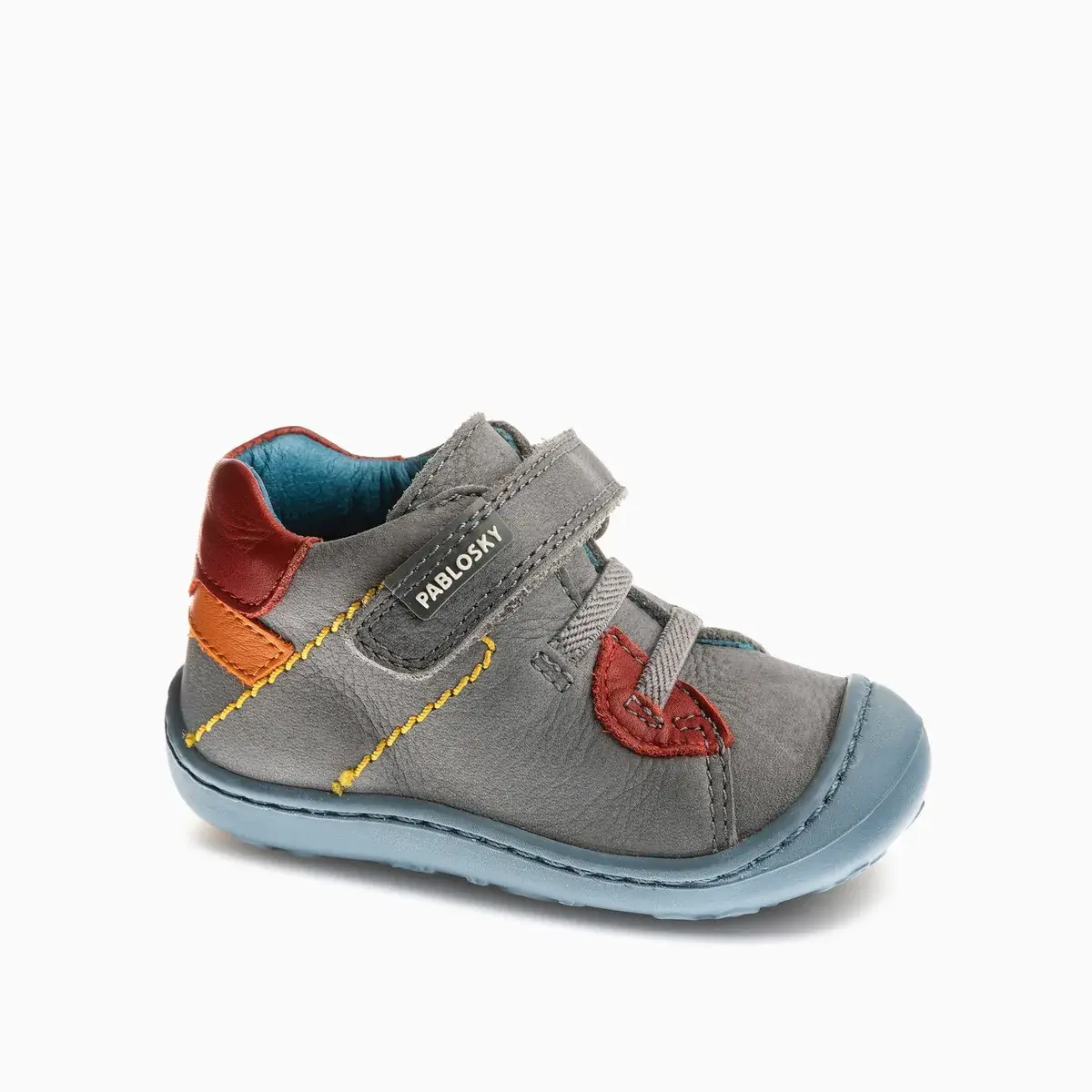 Botín Pablosky 032350 de piel gris con detalles rojos y azules y velcro, vista de tres cuartos